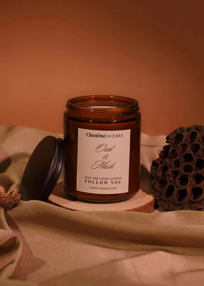 Amber glass jar scented candle with side lid and Oud & Musk label