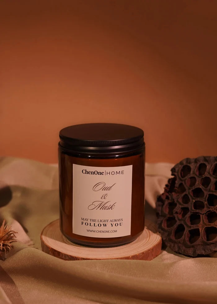 Amber glass jar scented candle with black lid and Oud & Musk label