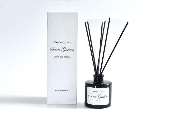 Black reed diffuser with four reeds and white gift box.