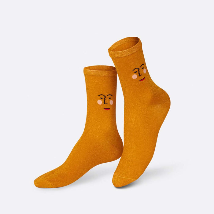 Pair of gold socks with and image o a face on the sides