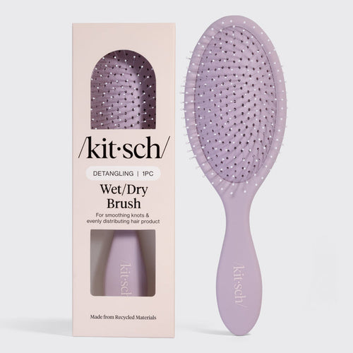 Kitsch Detangling Wet/Dry Brush in lavender, shown next to its blush pink retail packaging. Made from recycled materials, designed for smoothing knots and evenly distributing hair product.