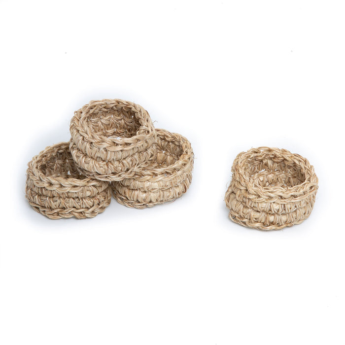 A set of four beige handwoven napkin rings on a white background.