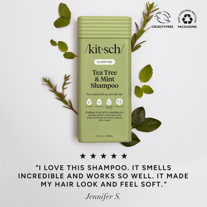 Kitsch Tea Tree & Mint Shampoo bottle with green leaves on a light gray background