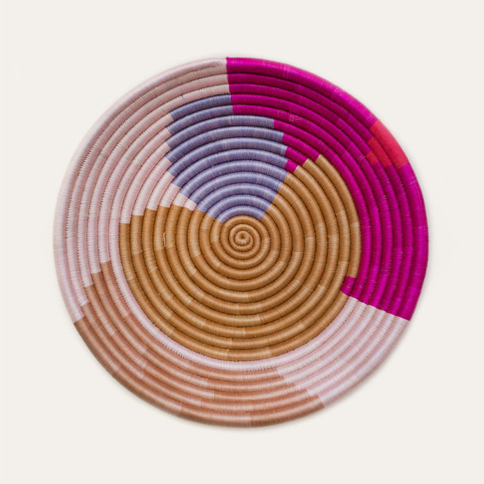 Colorful woven basket with concentric circle pattern on a light background