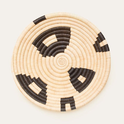 Woven basket with black and beige pattern on a white background