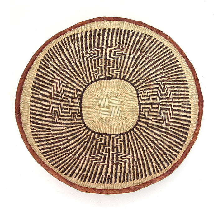A round, beige-colored woven basket with a geometric pattern and a coiled rim.