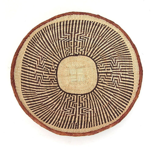 A round, beige-colored woven basket with a geometric pattern and a coiled rim.