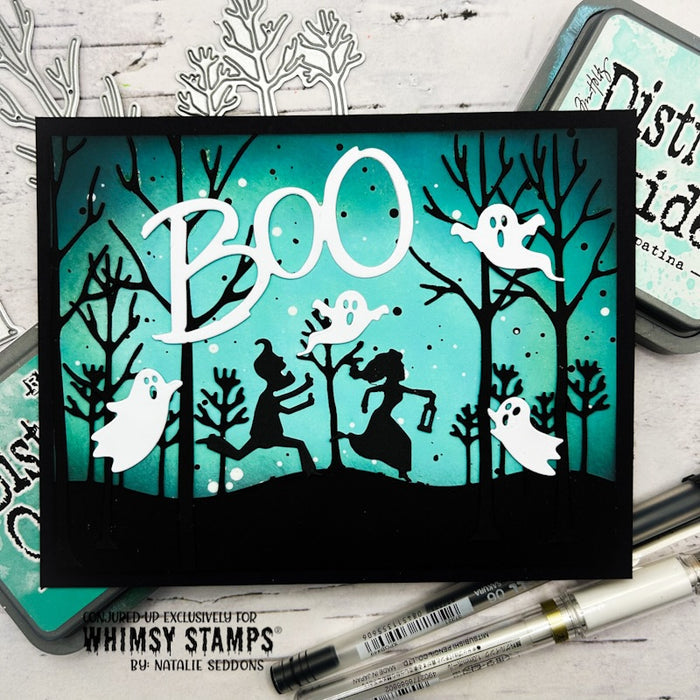 A handmade Halloween card featuring black silhouettes of trees, ghosts, and running figures on a teal sky background with large white 'BOO' lettering.