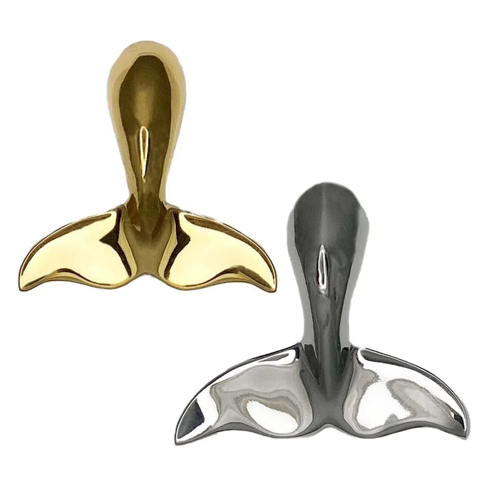 Gold and silver whale tail-shaped objects on a white background