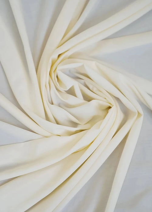 Cream wash-and-wear fabric with soft folds, close-up